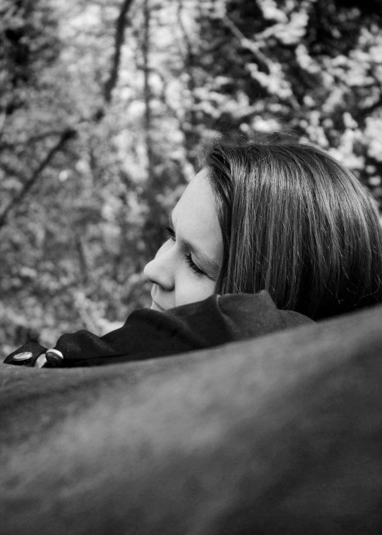 Inhaberin von Dalivhorses wie sie ihren Kopf auf dem Rücken ihres Pferdes ablegt